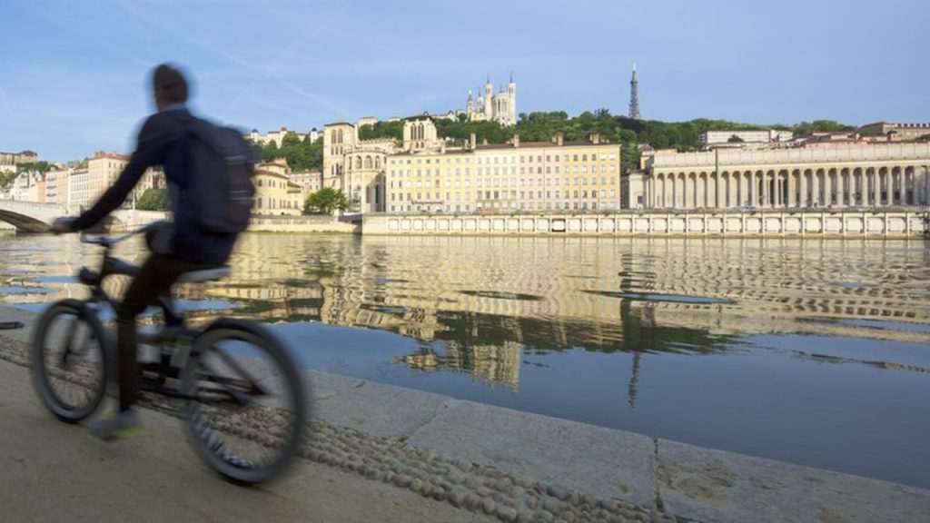 Cycliste devant les quais de Saône.