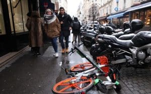 Vélo et trotinette en libre-service encombrant un trottoir parisien