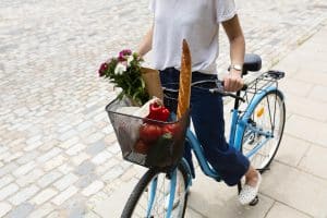 Femme utilisant à vélo pour faire ses courses dans un commerce de proximité