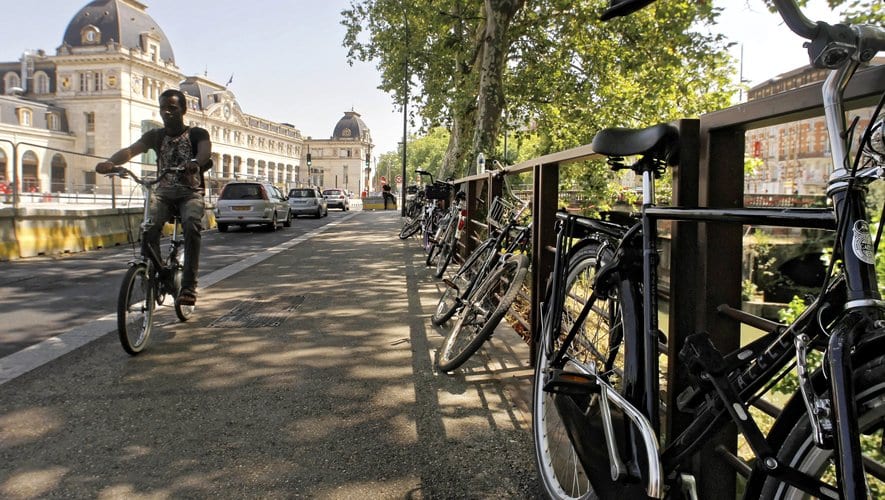 Sélection des meilleures applications vélo pour cyclistes urbains. Vélo stationnés et accrochés le long d'un canal.