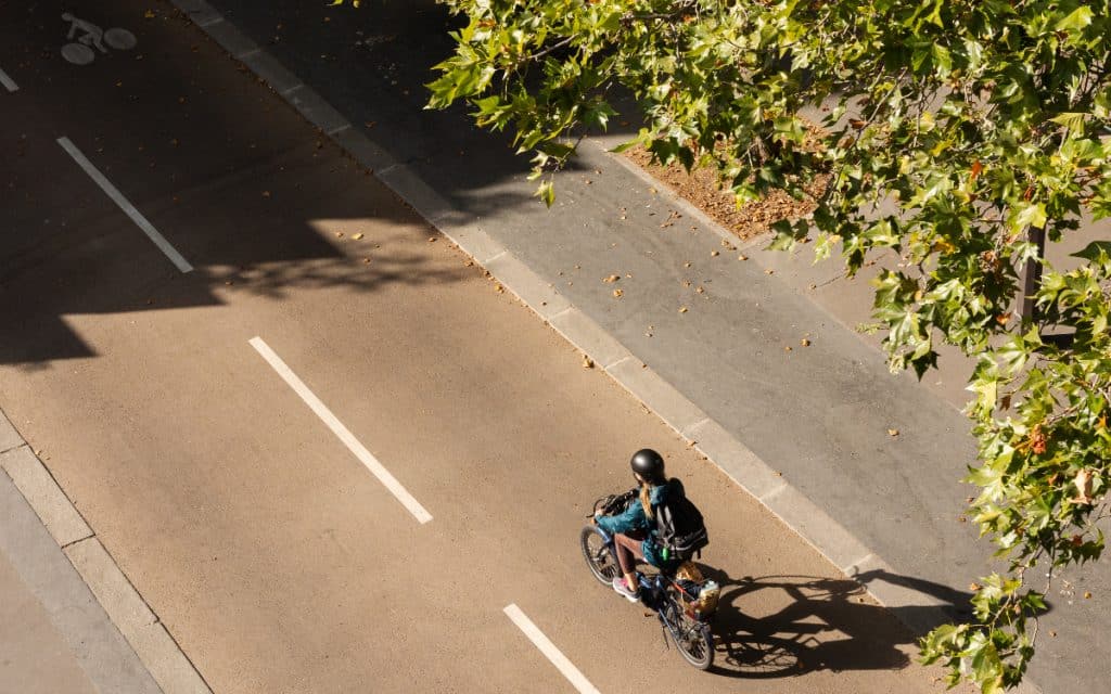 Sélection des meilleures applications vélo pour cyclistes urbains. Cycliste sur piste cyclable parisienne. 