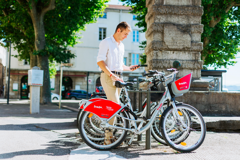 Sélection des meilleures applications vélo pour cyclistes urbains. Usager déverrouillant un vélo en libre service Fredo.