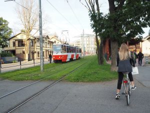 Femme à vélo croisant un tramway dans les rues de Tallinn, capitale estonienne.